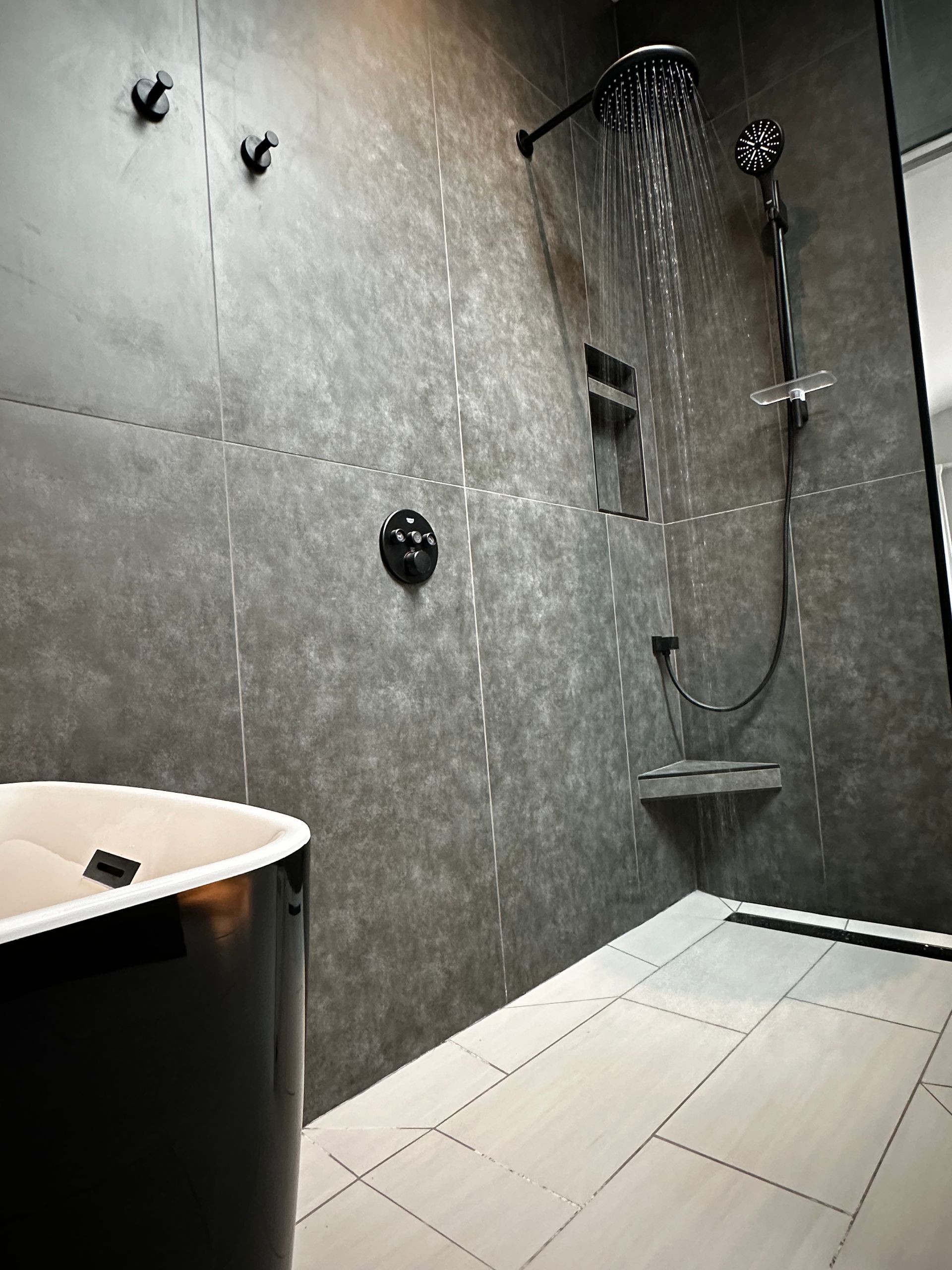 A bathroom with a tub , shower , and mirror.
