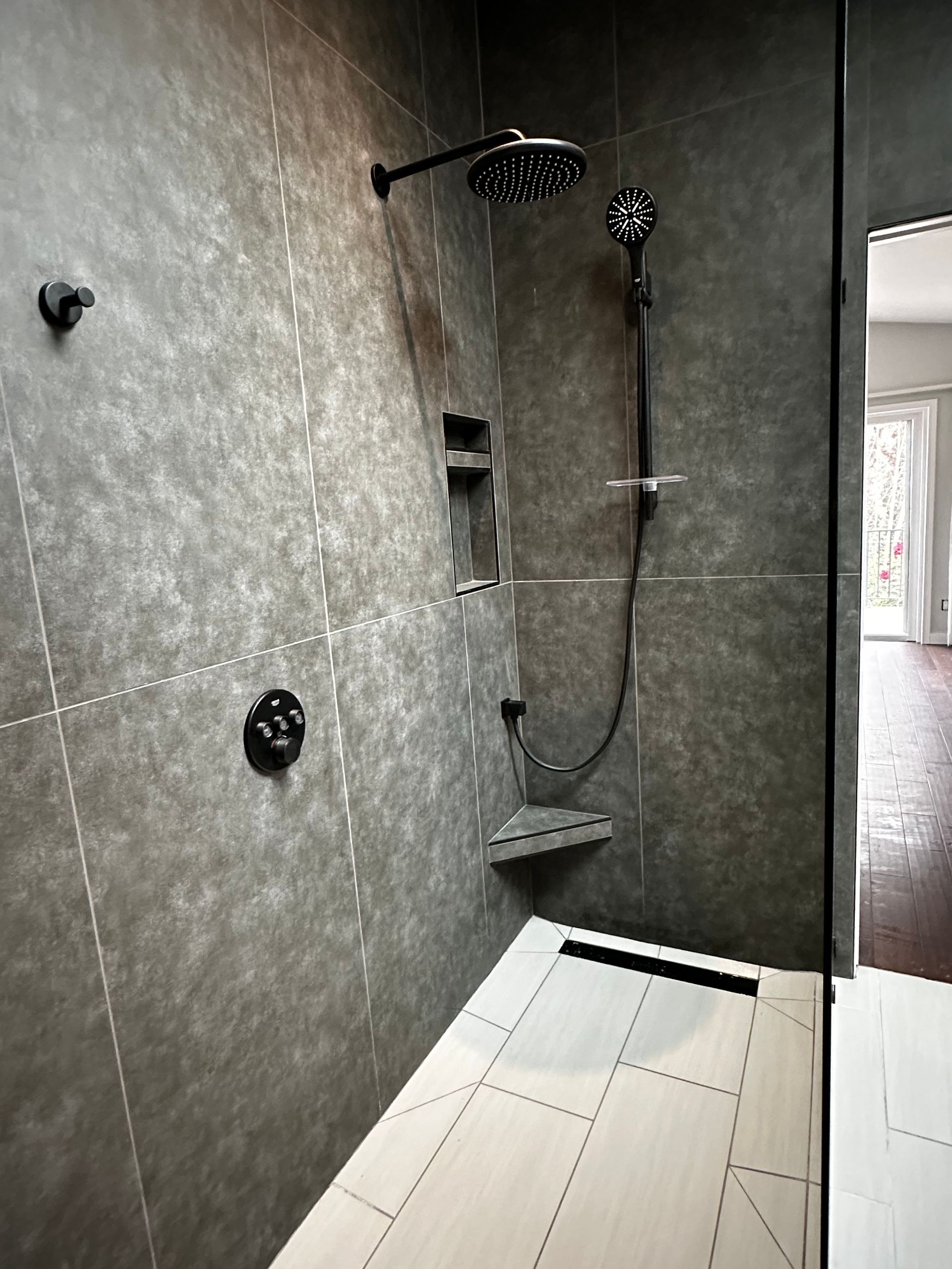 A bathroom with a walk in shower and a shower head.