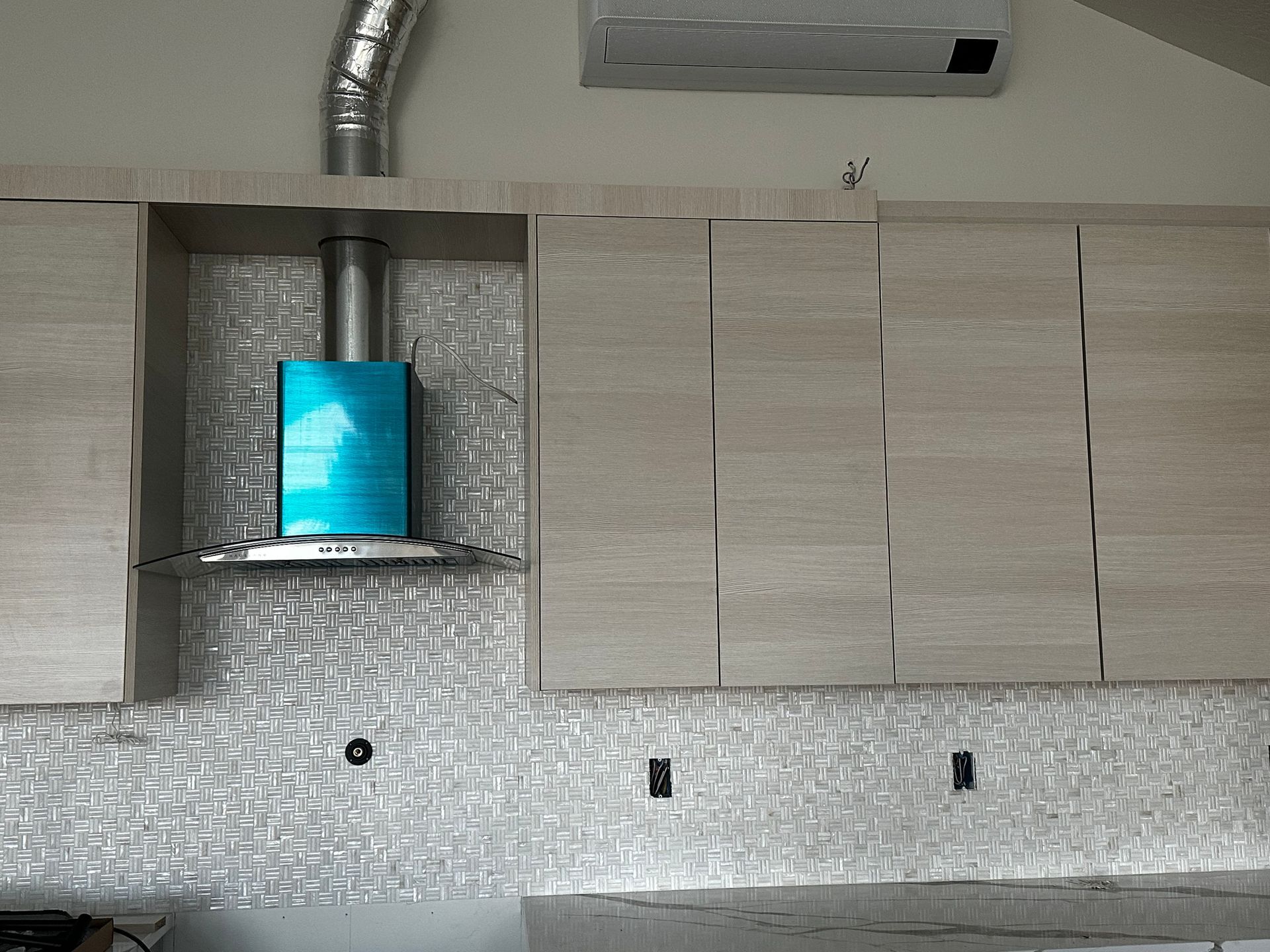 A kitchen with wooden cabinets and a blue hood