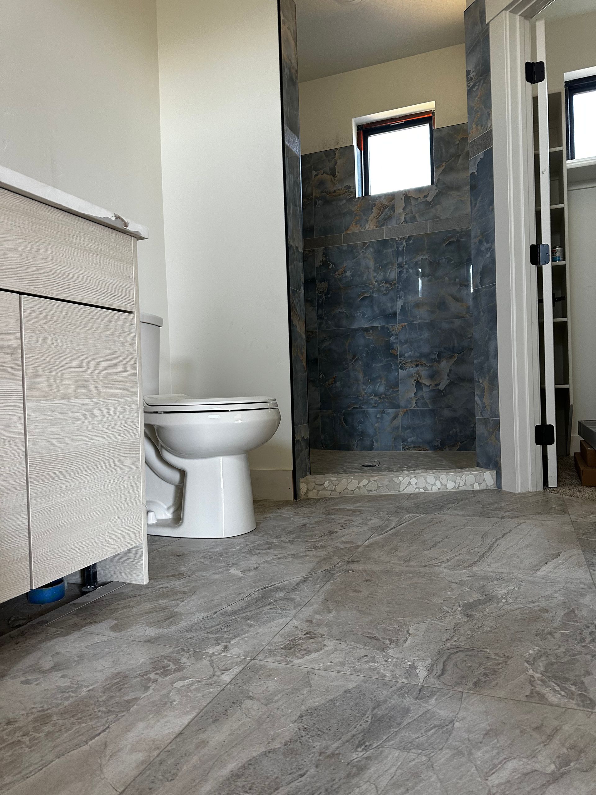 A bathroom with a toilet , sink , and shower.
