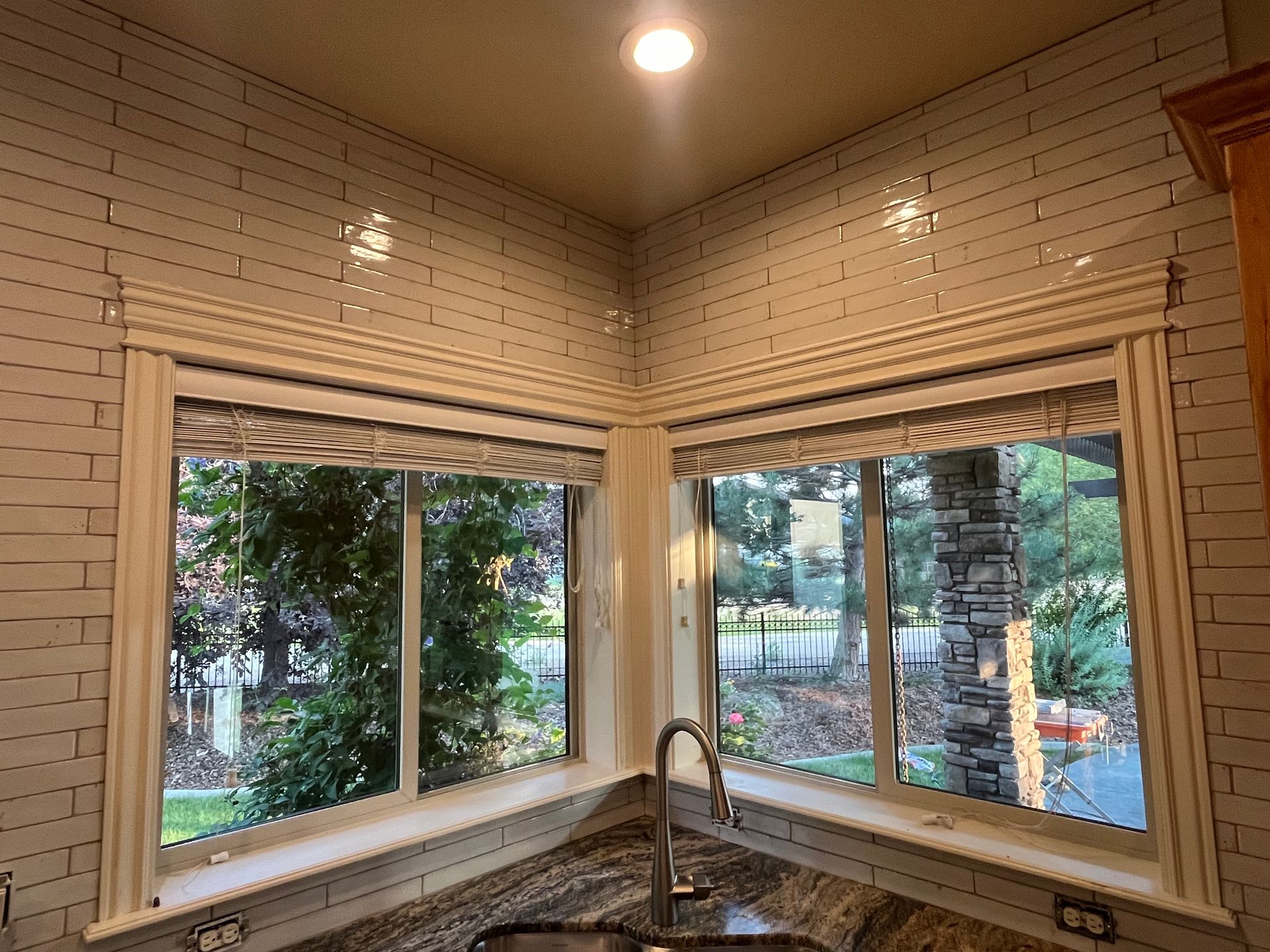 A kitchen with a sink and a window with a view of a garden.