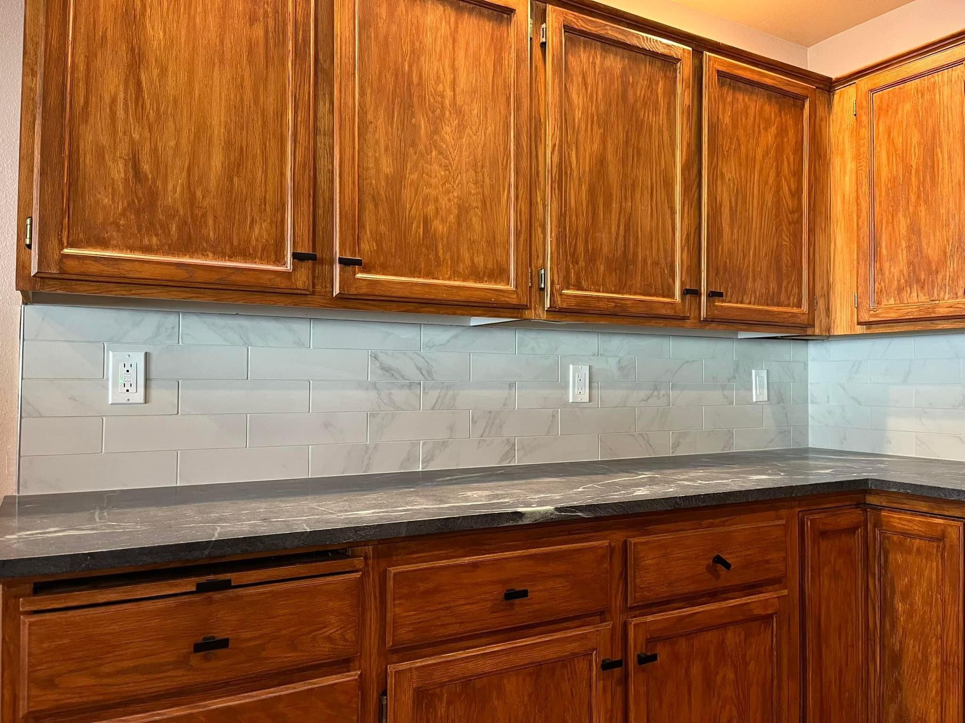 A kitchen with wooden cabinets and granite counter tops.