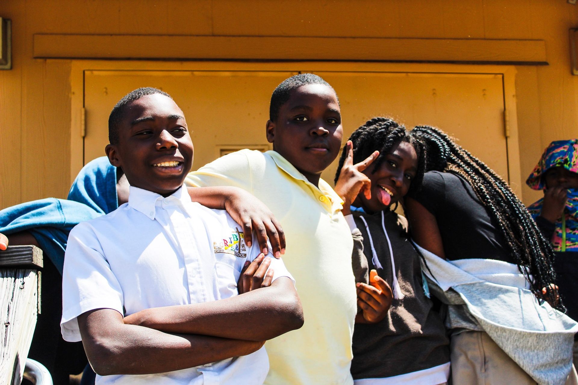A group of young people are posing for a picture in front of a building.