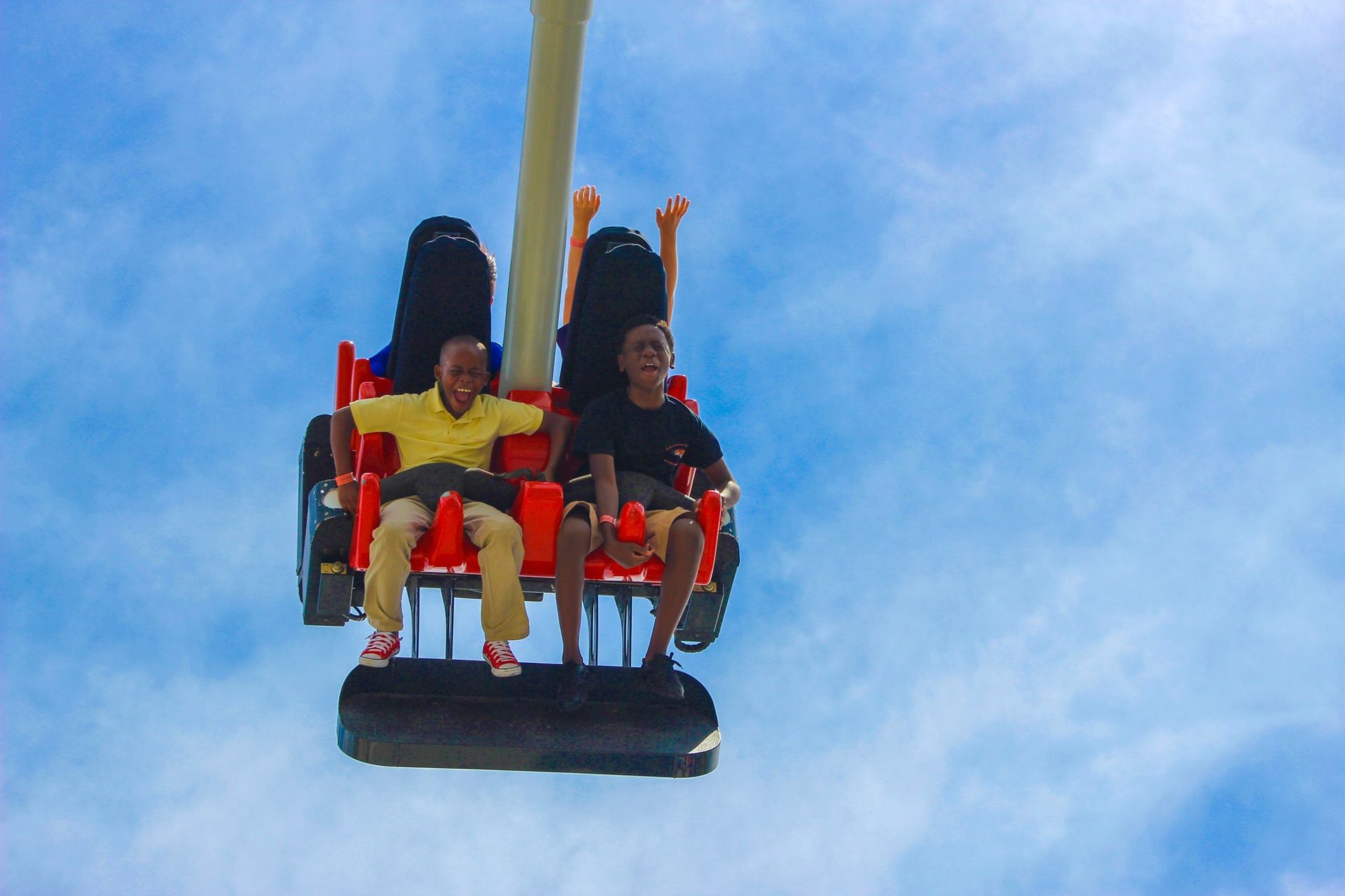Two people are riding a roller coaster in the sky.