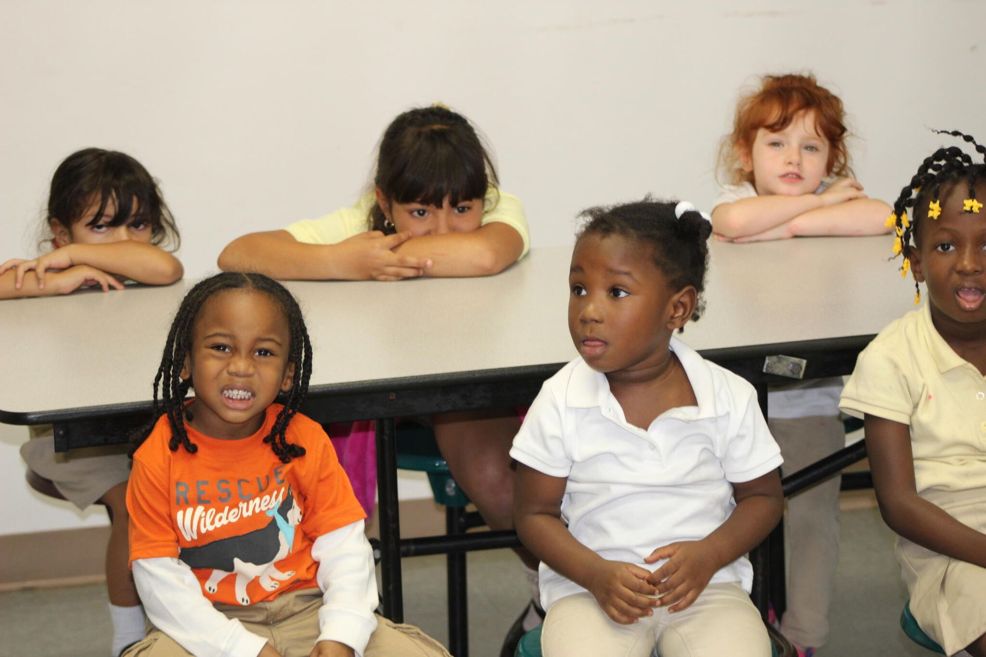 A boy wearing an orange shirt that says arctic whales