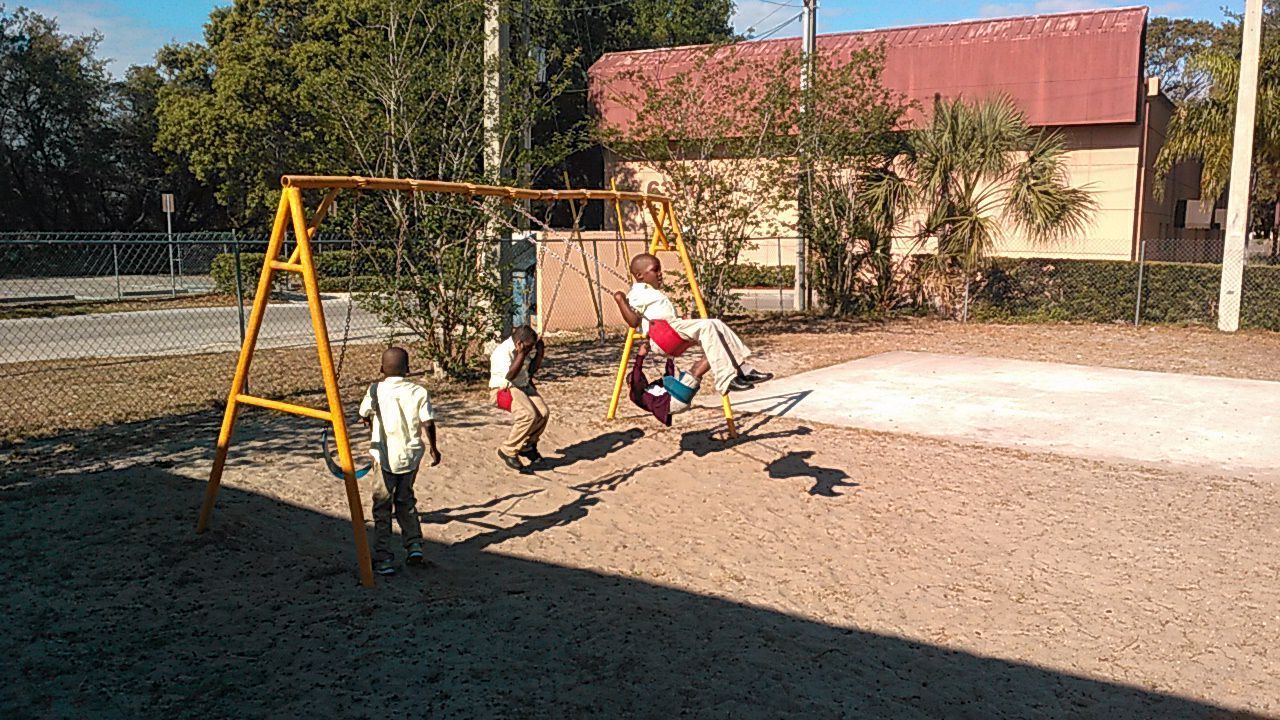 A group of children are playing on swings in a playground.