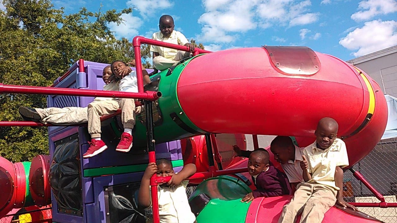 A group of children are playing on a colorful playground.