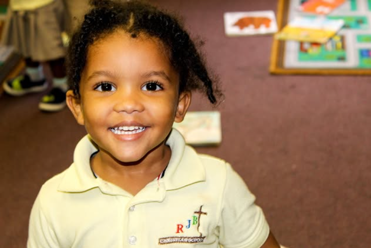 A little girl wearing a shirt with the letter r on it