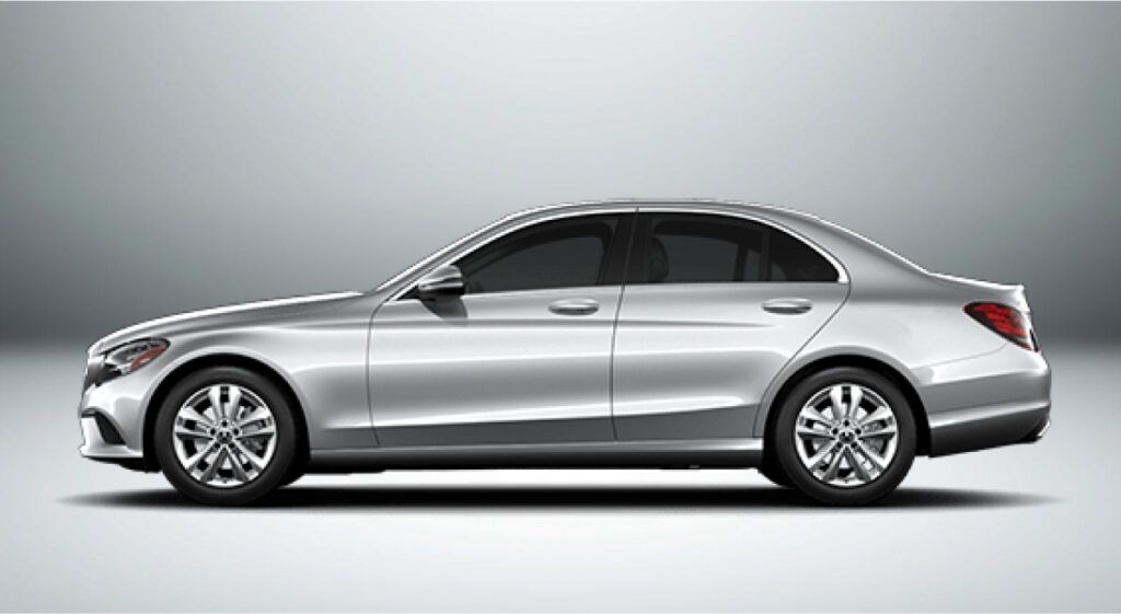 Um sedã prata mercedes benz classe c é mostrado de lado em um fundo branco.