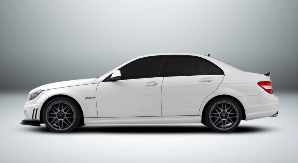 Um carro branco com rodas pretas está parado em uma superfície branca.