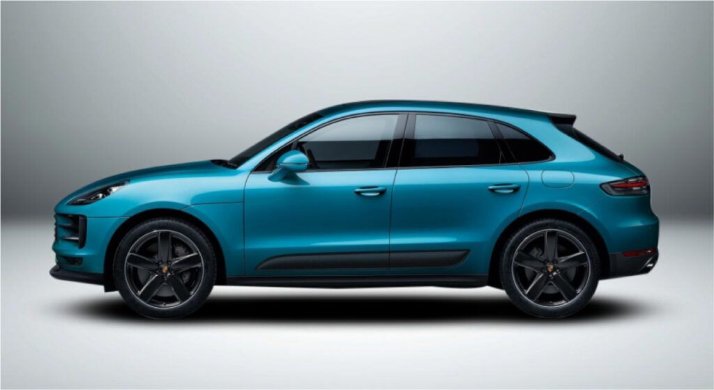 Um porsche macan azul está sentado sobre uma superfície branca.