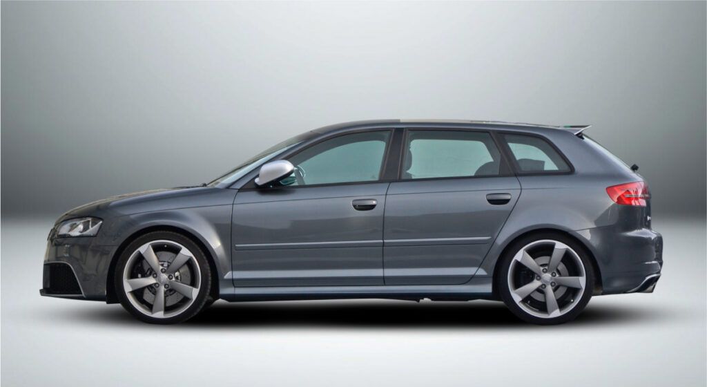 Um carro cinza está estacionado em uma superfície branca.