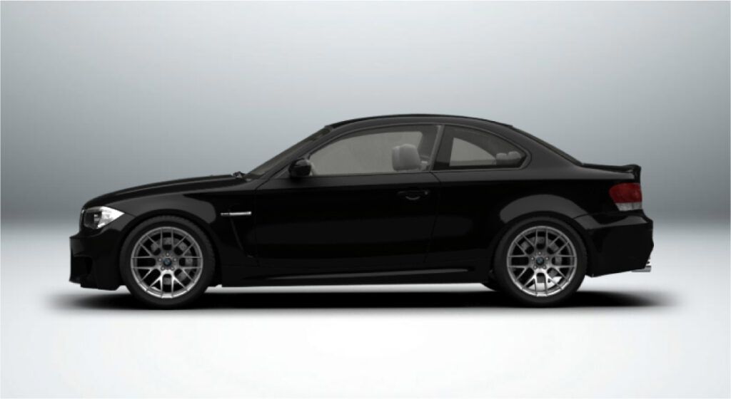 Um cupê bmw m1 preto está sentado em uma superfície branca.