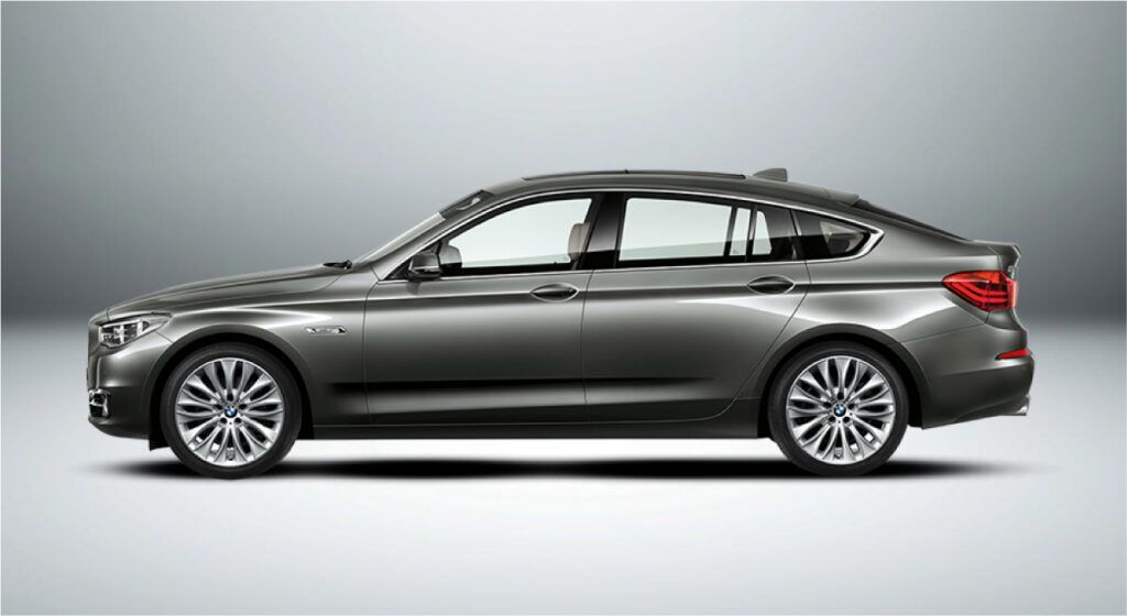 Um bmw série 5 é mostrado de lado em um fundo branco.