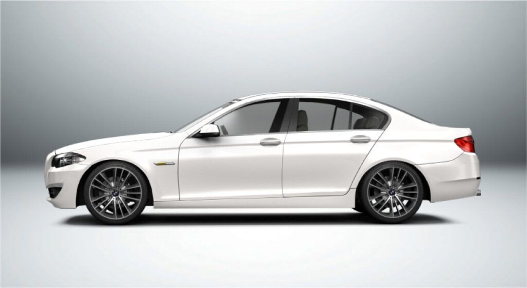 Um carro branco com rodas pretas está parado em uma superfície branca.