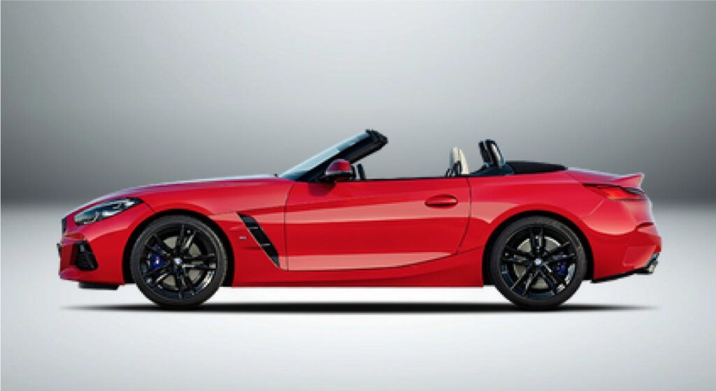 Um bmw z4 conversível vermelho é mostrado de lado em um fundo branco.