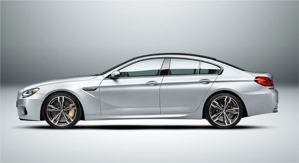 Um bmw m6 prateado é mostrado lateralmente em um fundo branco.