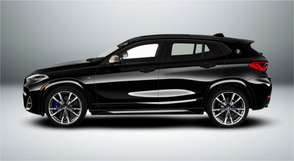 Um bmw x2 preto está sentado em uma superfície branca.