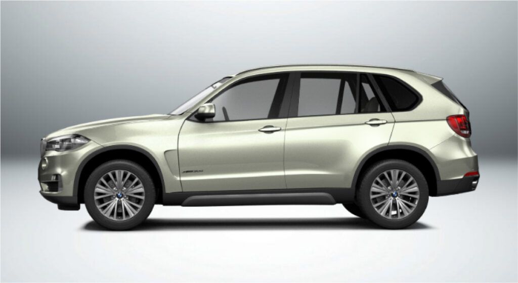 Um bmw x5 prateado está sobre uma superfície branca.