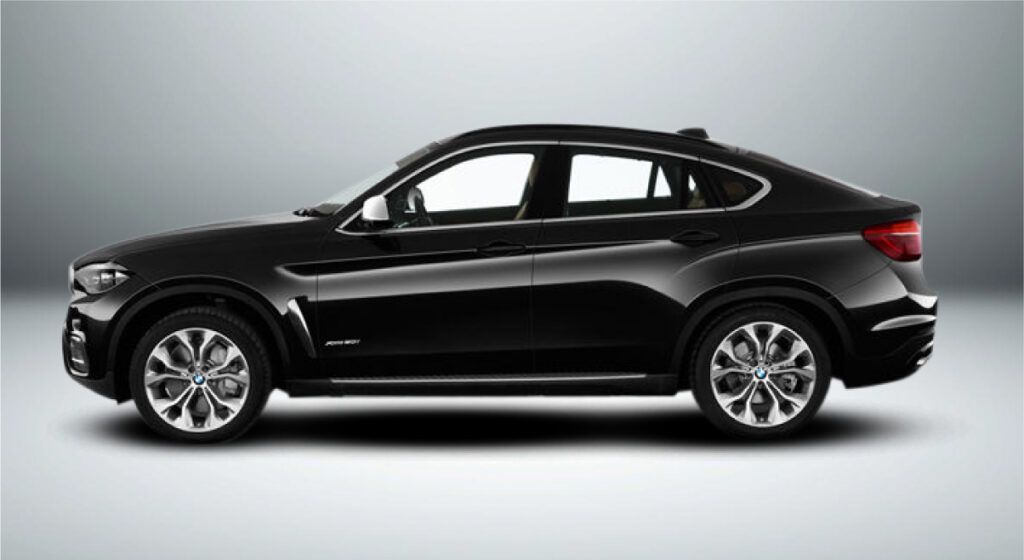Um bmw x4 preto está sentado em uma superfície branca.