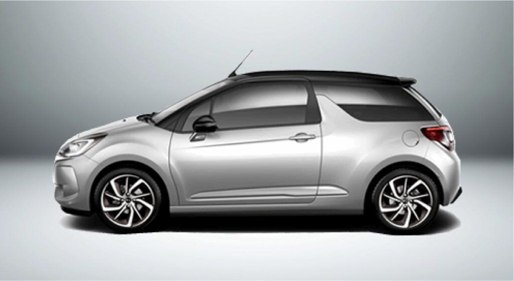 Um carro prateado com teto preto está parado em uma superfície branca.