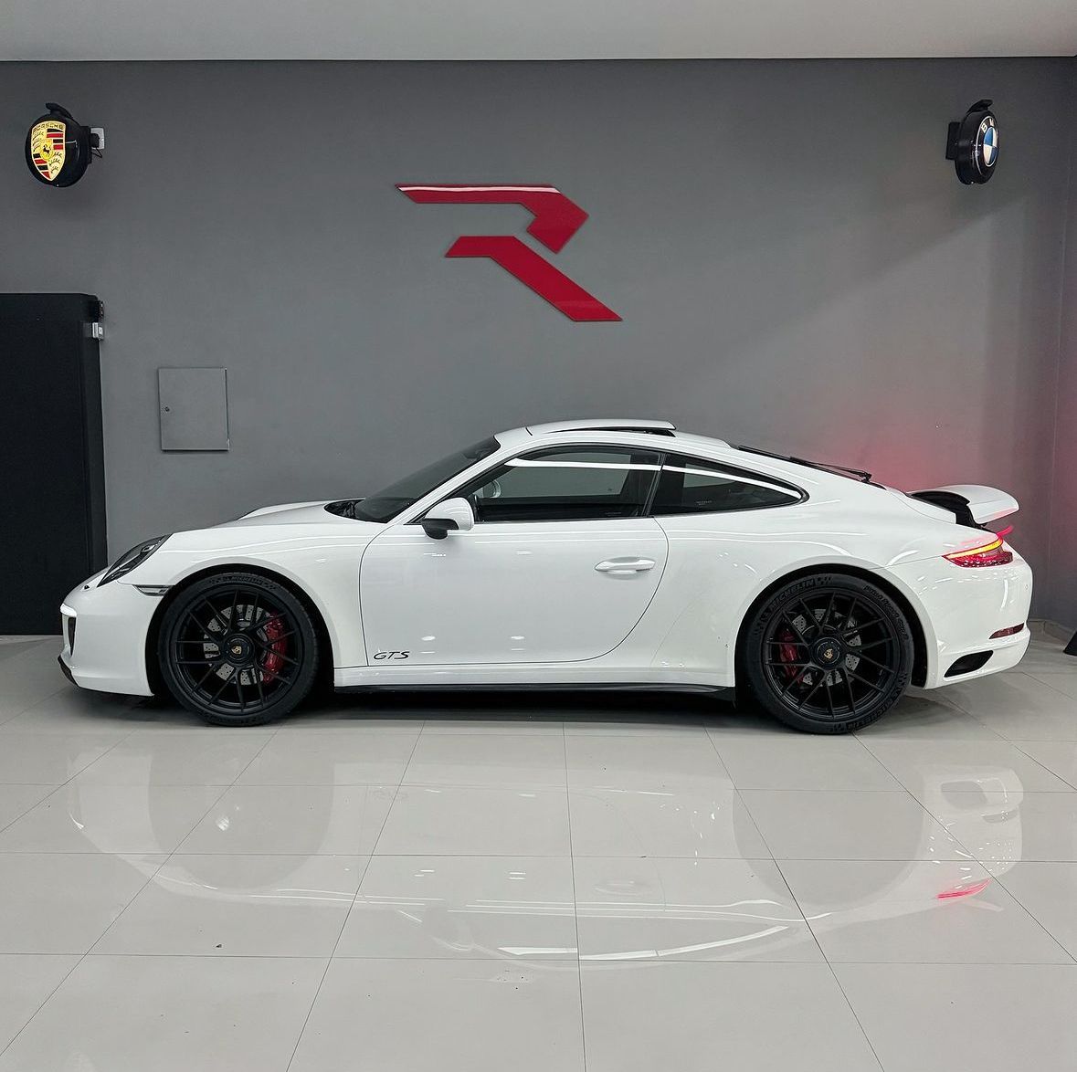 Um porsche 911 branco está estacionado em um showroom.