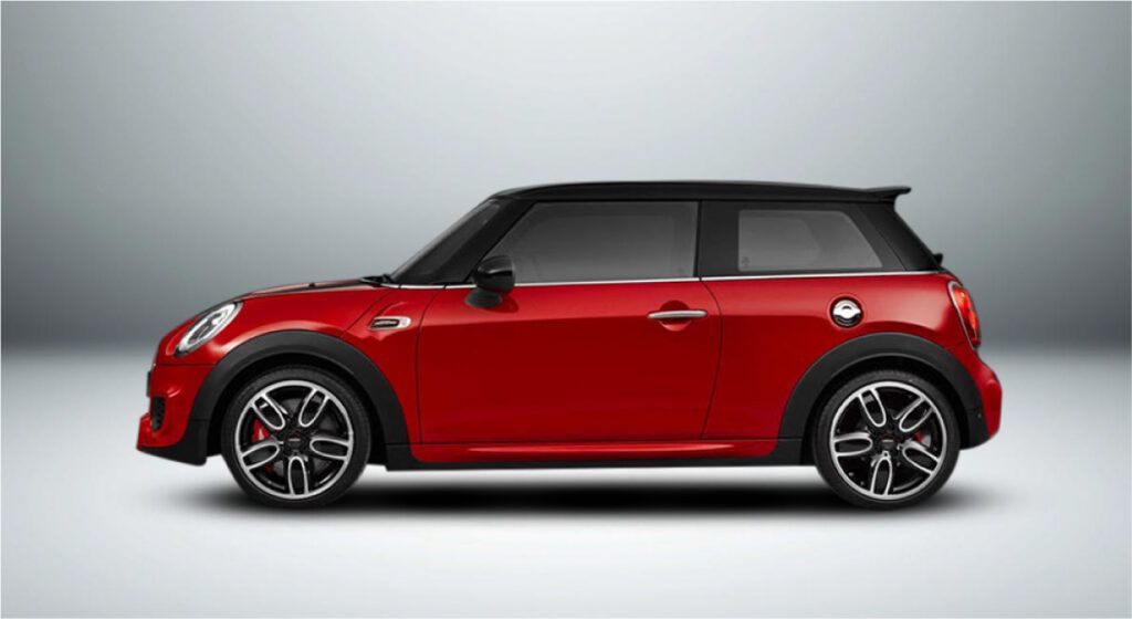 Um mini cooper vermelho está sentado em uma superfície branca.