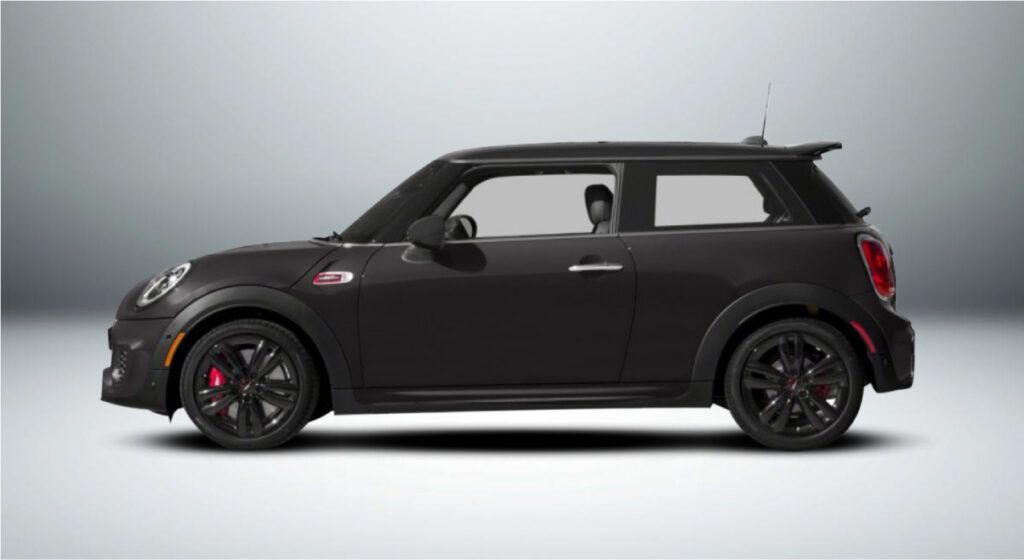 Um mini cooper preto está sentado em uma superfície branca.