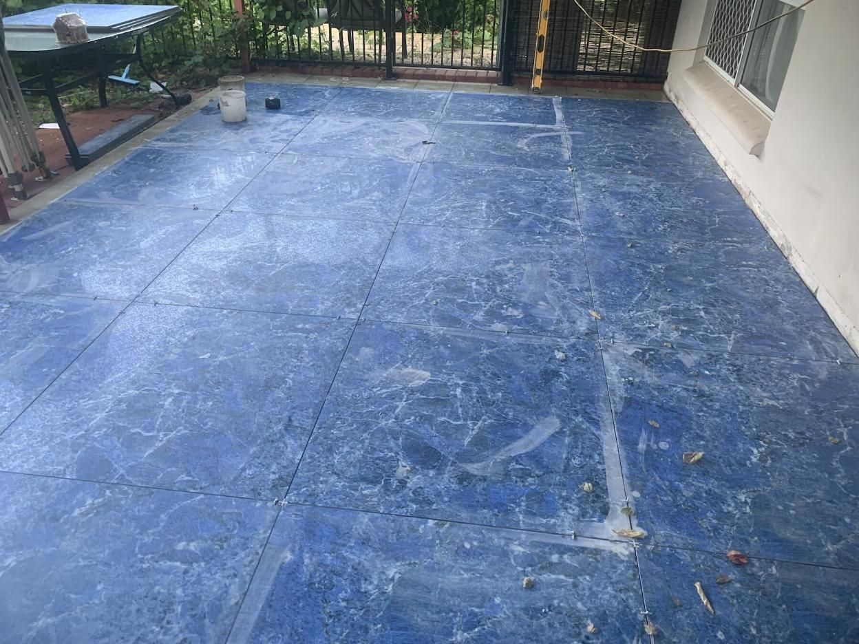 Bluish Grey Marble Tiles with Black Barricade in Background — Paving in Darwin River, NT