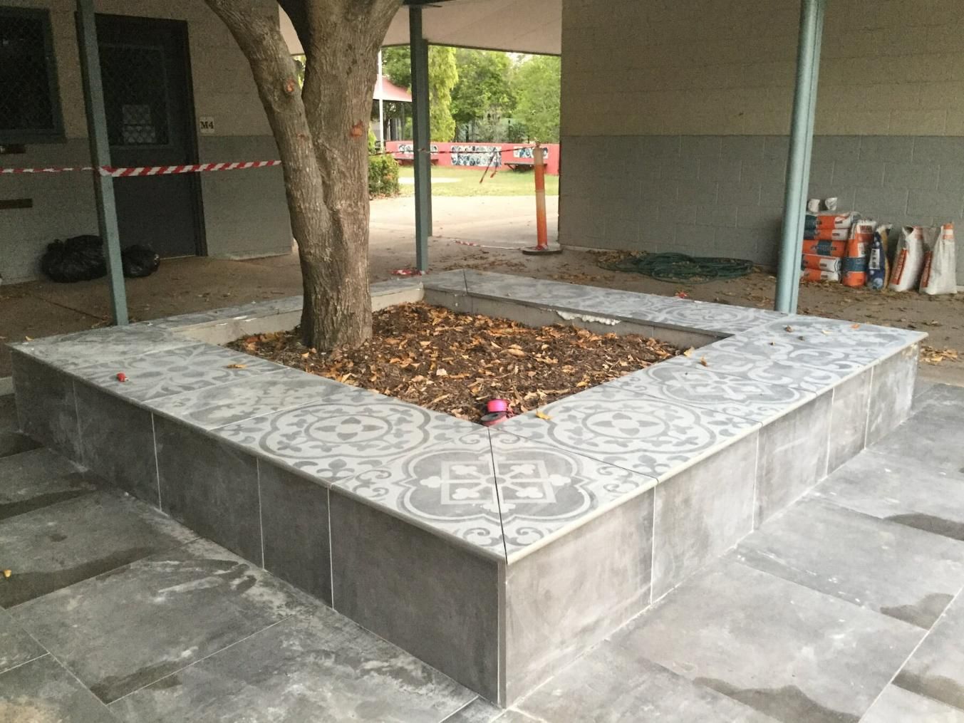 A Tree Trunk Surrounded with Compound Tiles — Paving in Darwin River, NT