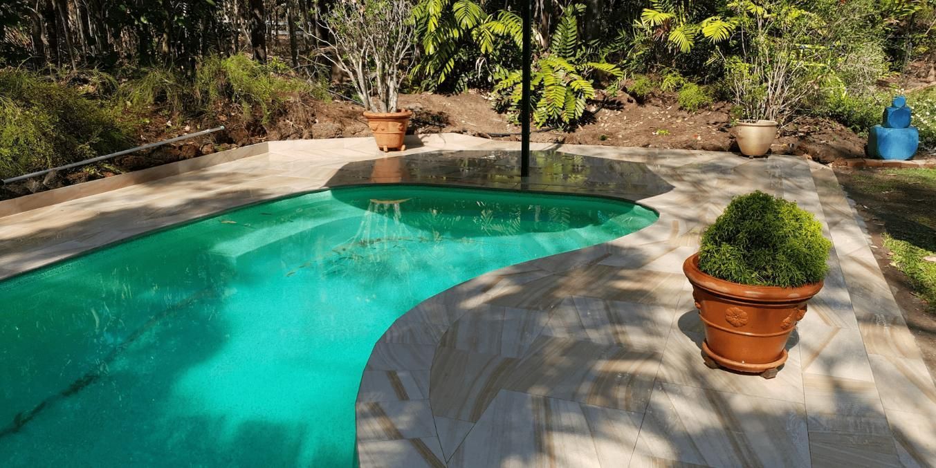 Large Swimming Pool Surrounded By Trees And Potted Plants — Paving in Darwin River, NT