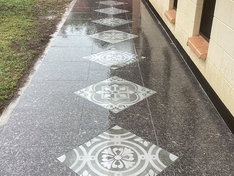 A Sidewalk with A Pattern on It and A Building in The Background — Paving in Darwin River, NT
