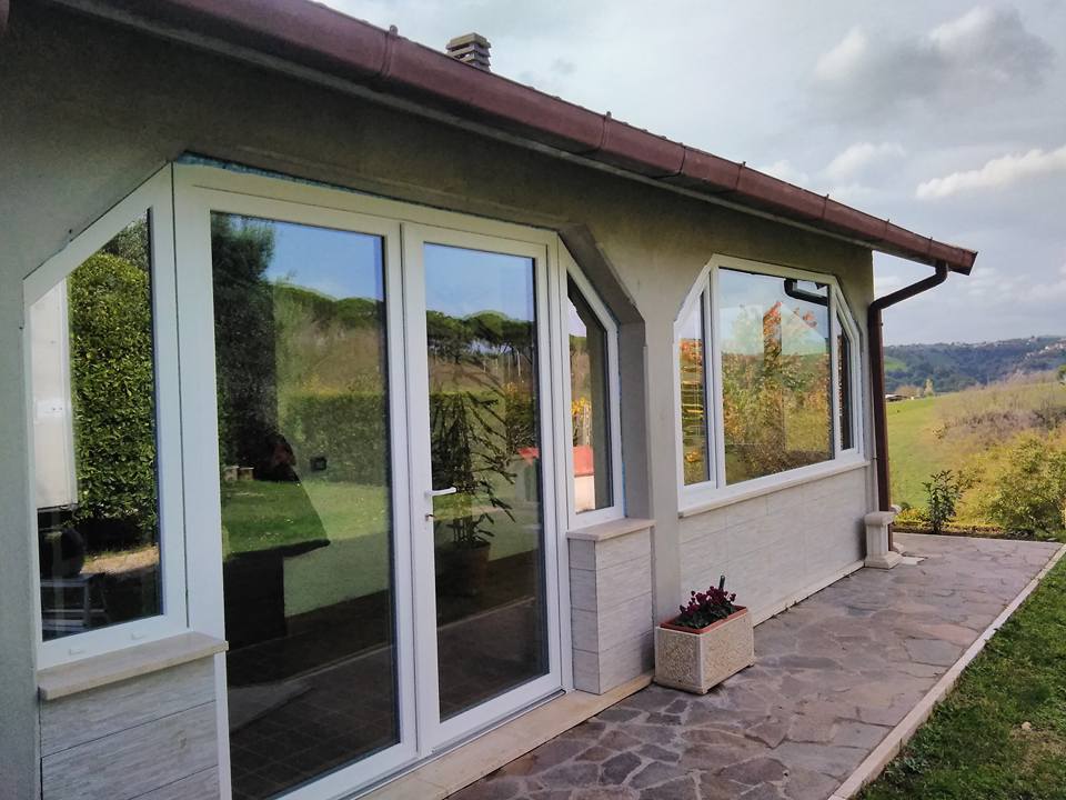 casa unifamiliare con finestre in legno e alluminio