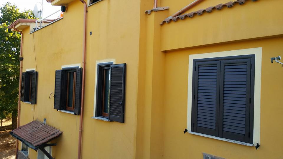 palazzina con intonaco giallo e persiane verdi