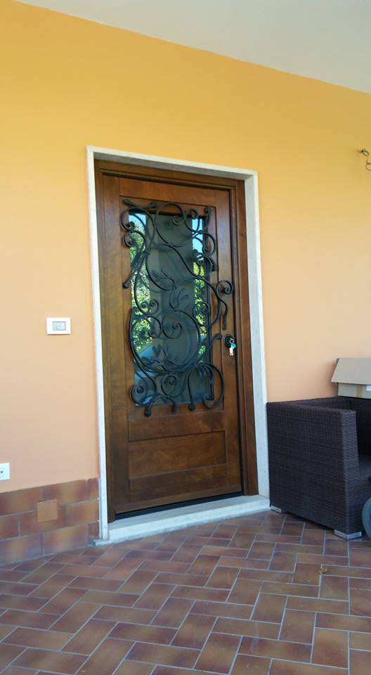 porta blindata in legno con decorazione in ferro battuto