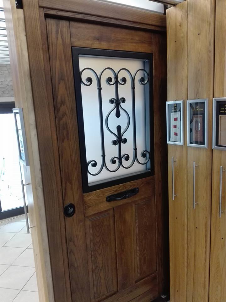 porta in legno e vetro con decorazione in ferro battuto