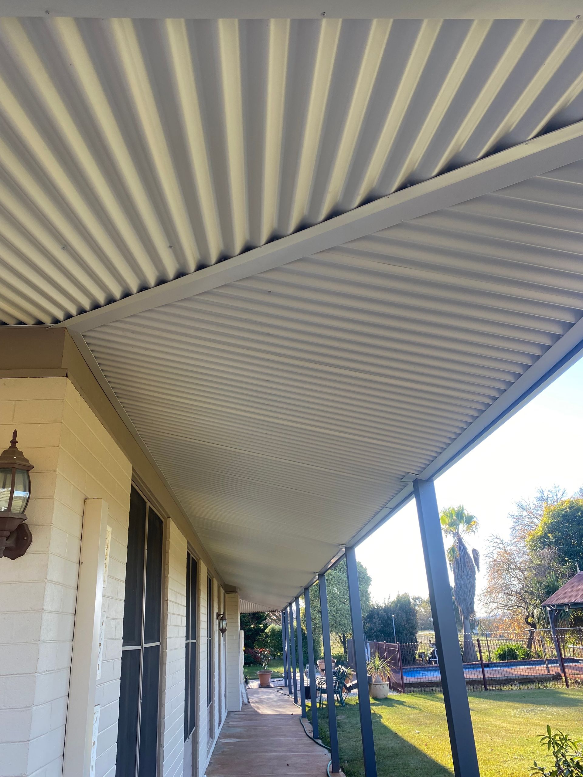A House With A Brown Roof And A White Garage Door — Matt Walsh Plumbing in Thurgoona, NSW