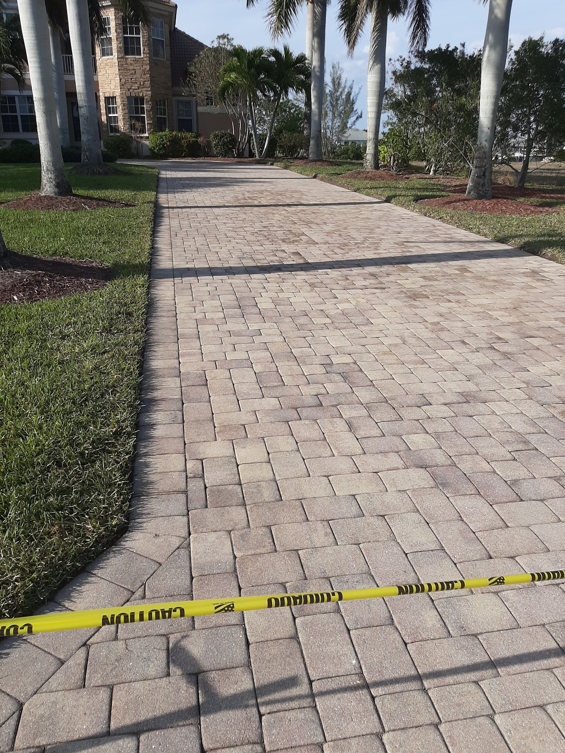 A brick walkway with a yellow caution tape on it