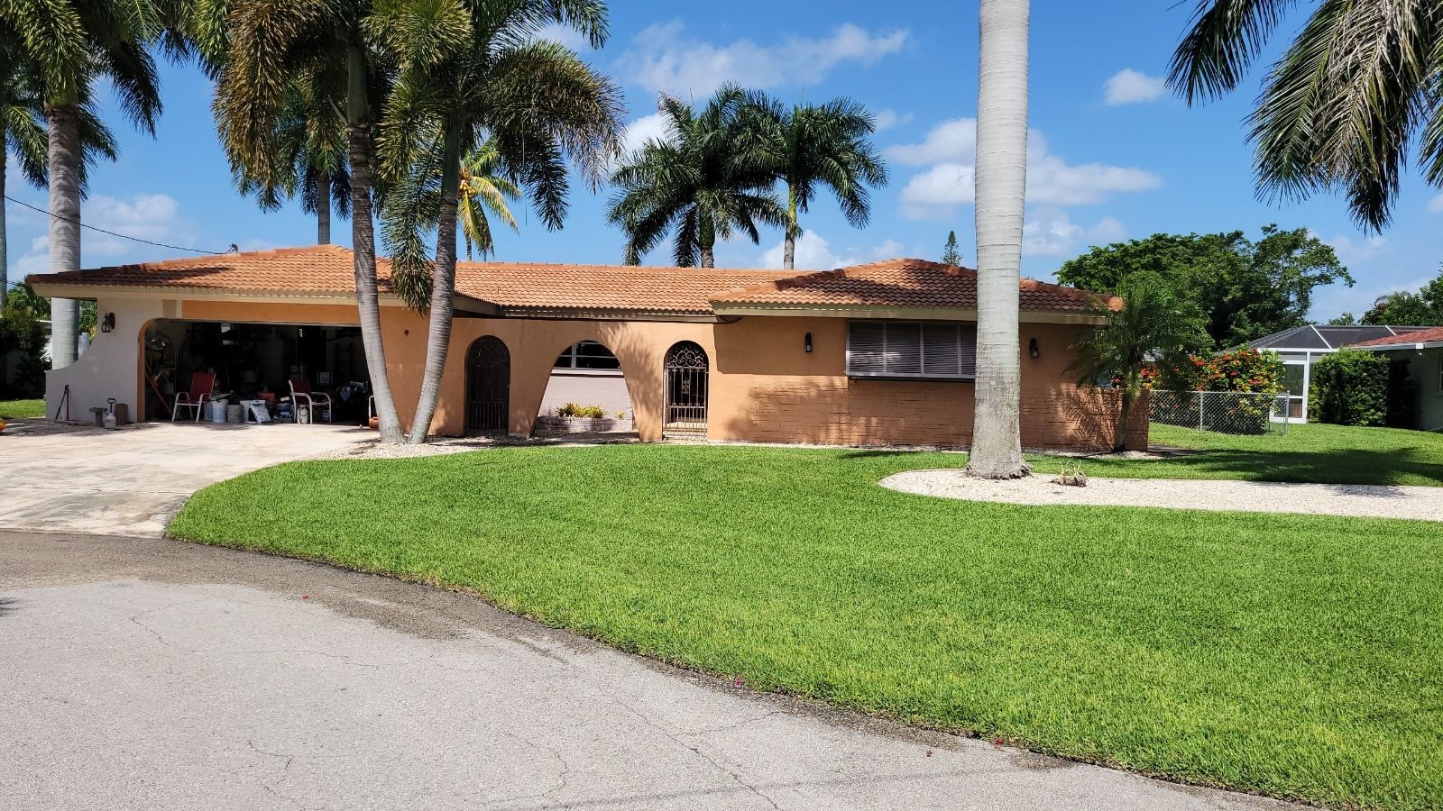 A house with a garage and palm trees in front of it
