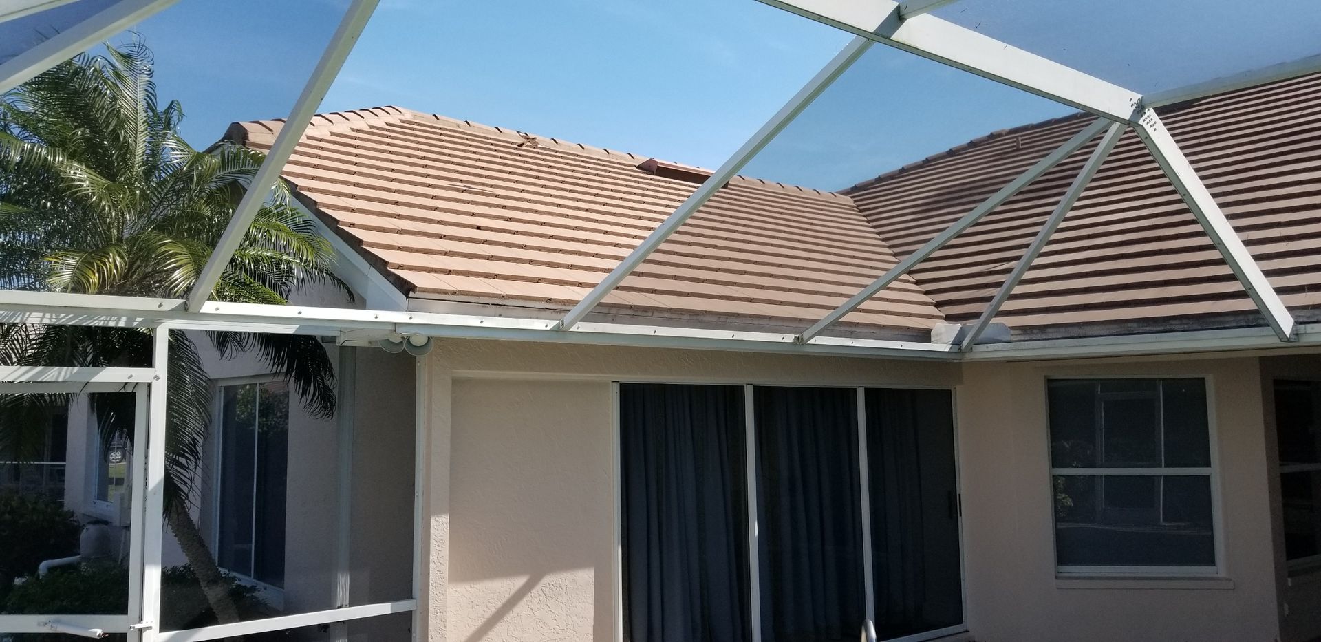 A house with a screened in porch and a roof