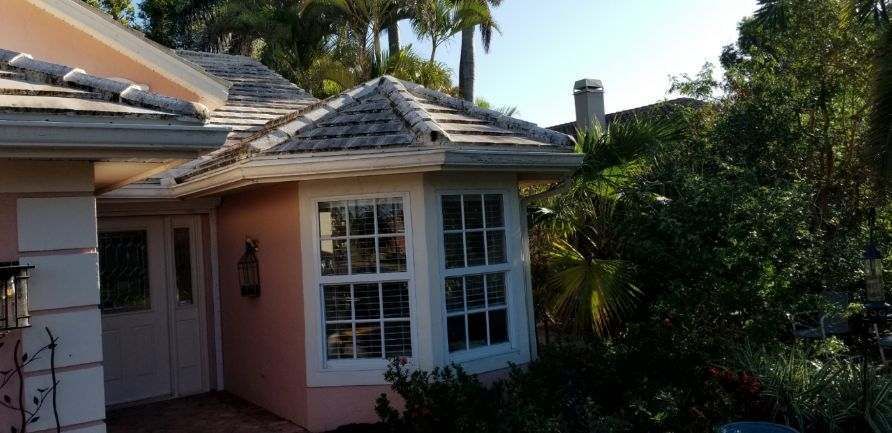 A pink house with a white roof and a lot of windows