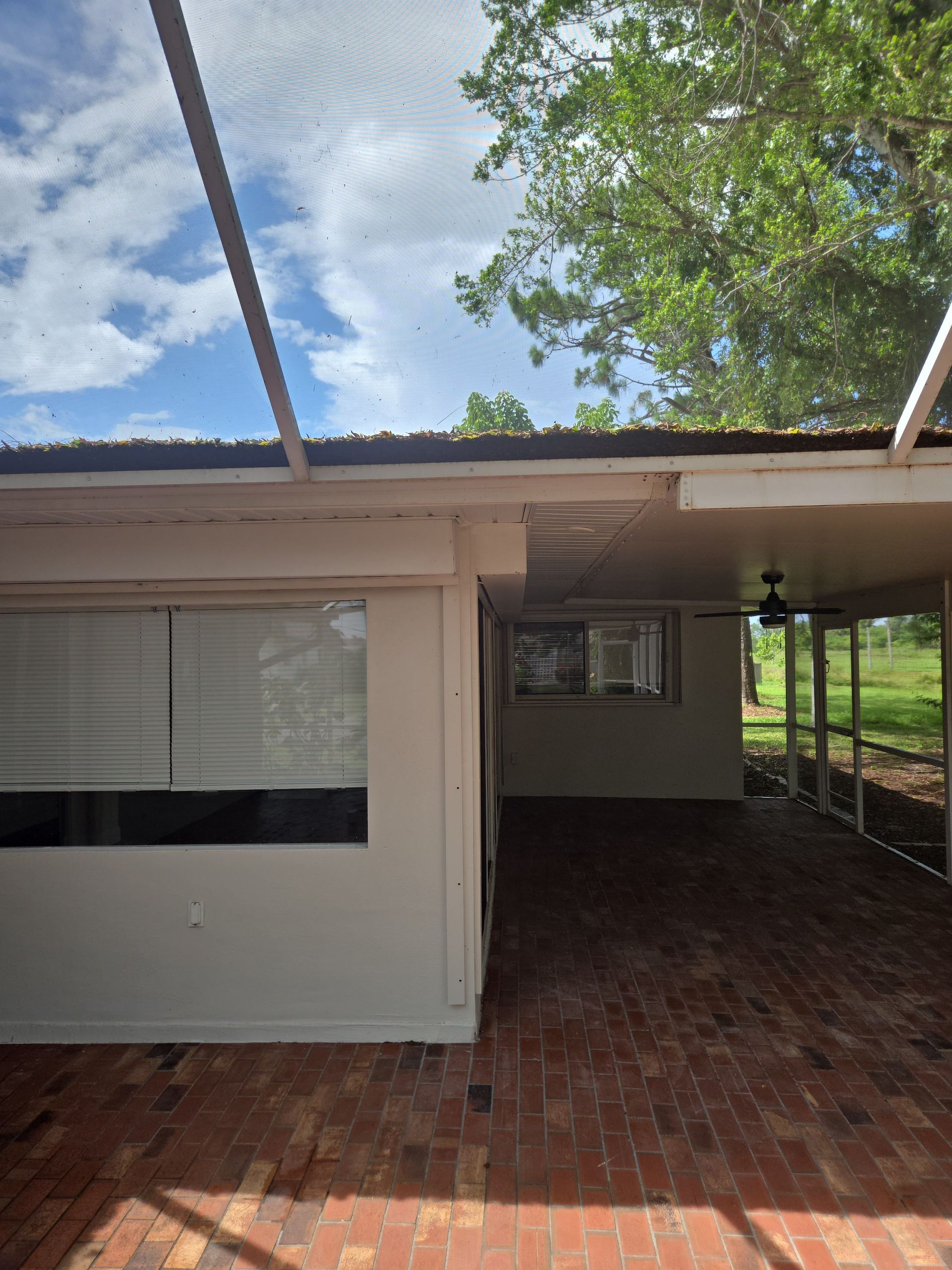 A house with a screened in porch and a ceiling fan
