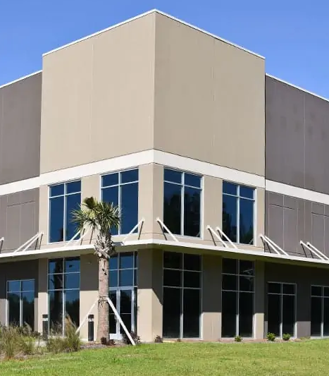 A large building with a lot of windows and a palm tree in front of it