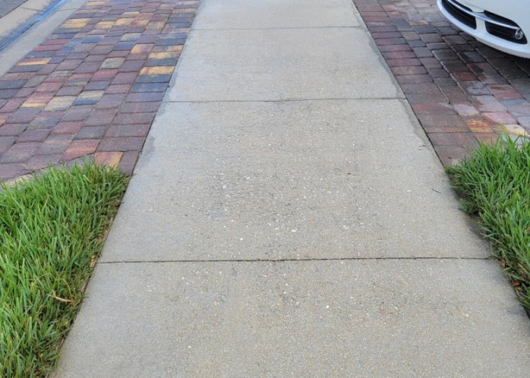 A white car is parked on the side of the road next to a sidewalk.