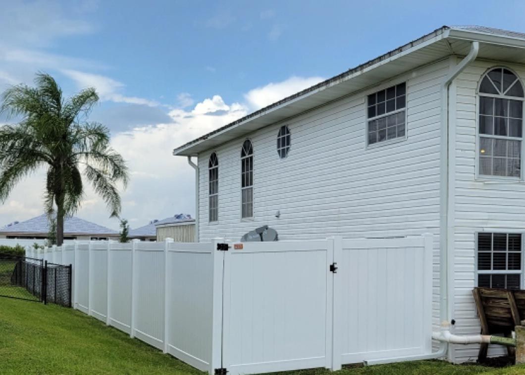 A white house with a white fence in front of it.