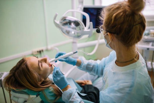 Lapeer Family Dental offers dentist services in Metamora, ID, showing a dentist doing a dental checkup on a female patient.