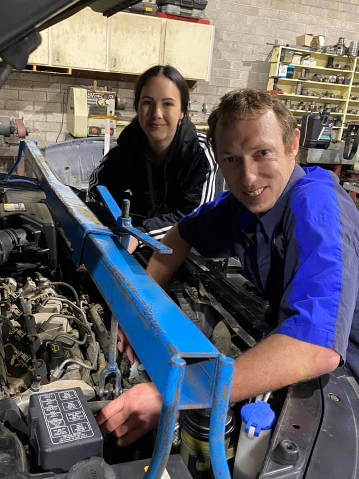 A Man and a Woman Are Working on a Car Engine in a Garage — Town & Country Removals In Taree, NSW