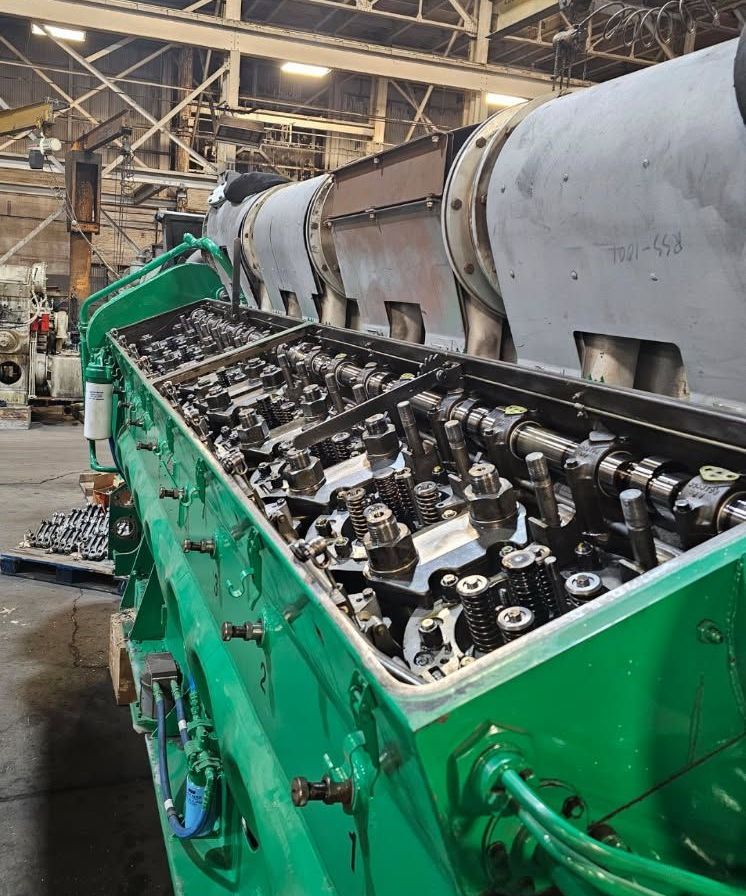 A train is going down the tracks in a field.