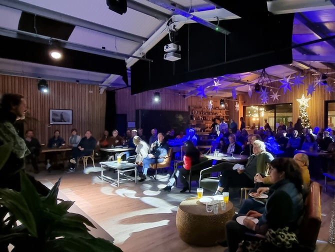 A group of people are sitting at tables in a room.