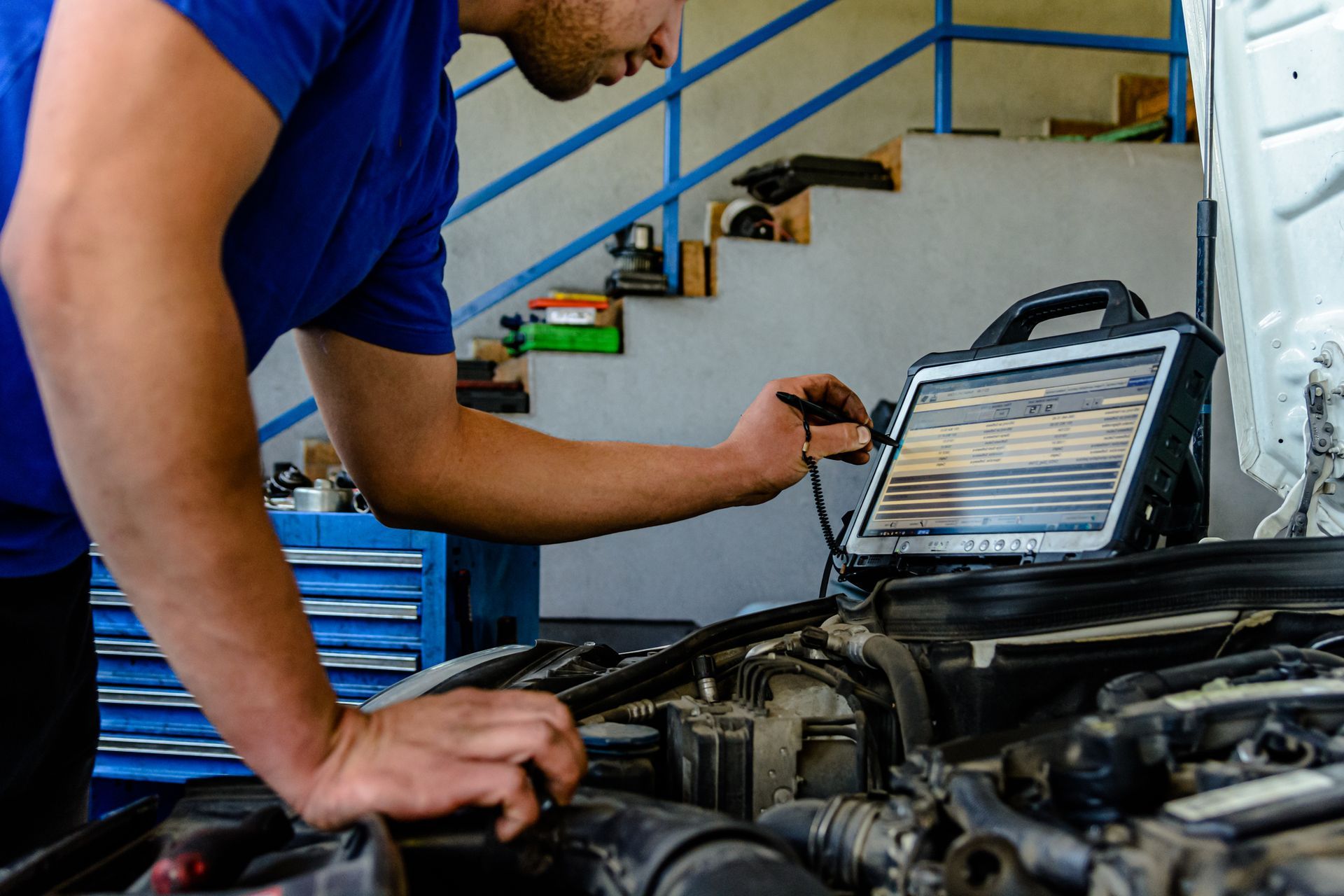 A man is working on a car engine in a garage.